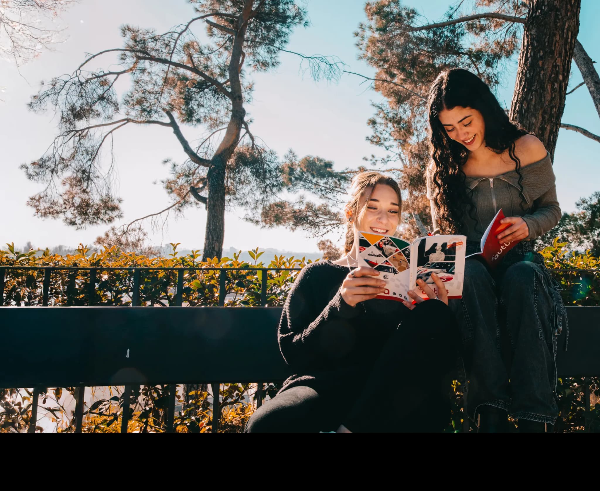Dos alumnas de autoescuela Autius estudiando el manual de teórica al aire libre